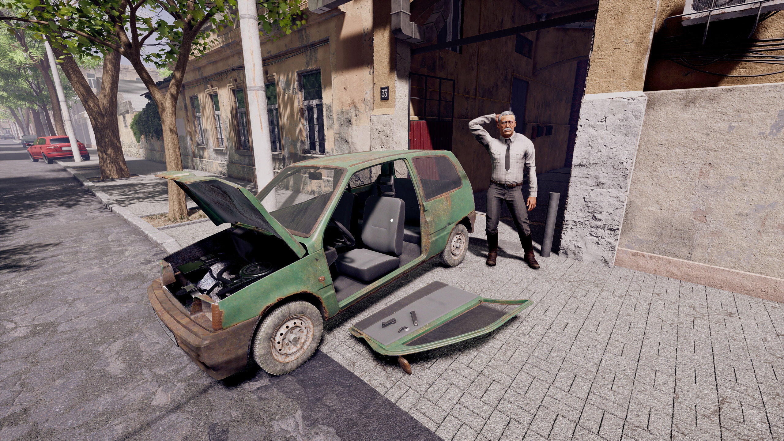A distressed car dealer stands next to a broken-down vehicle in a city street.
