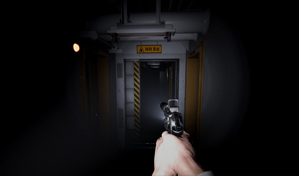 First-person view of a character holding a gun in a dark corridor aboard a ship.